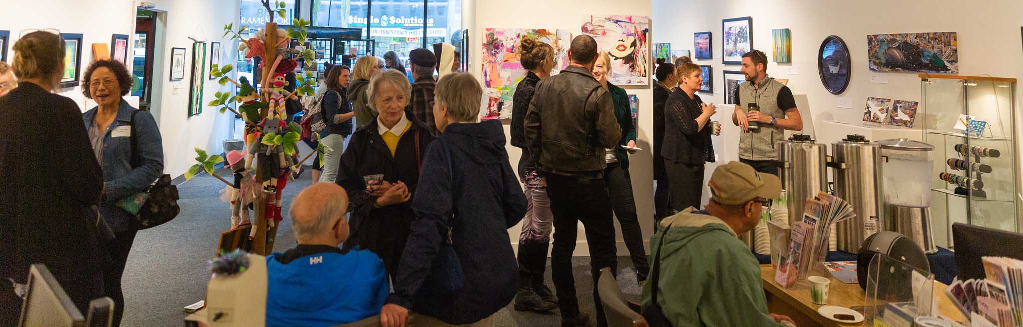 A large group of people milling about at an art opening
